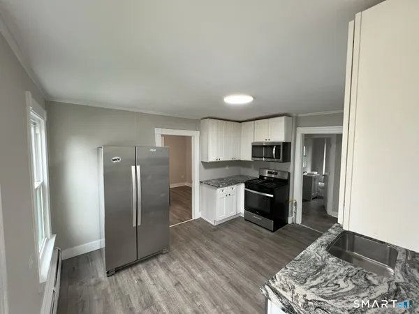 a kitchen with stainless steel appliances granite countertop a refrigerator stove and oven