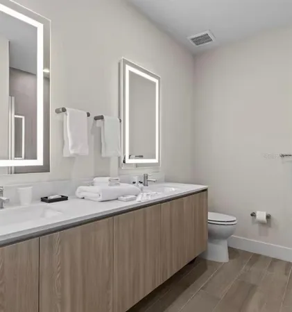 a bathroom with a granite countertop sink a toilet and a mirror