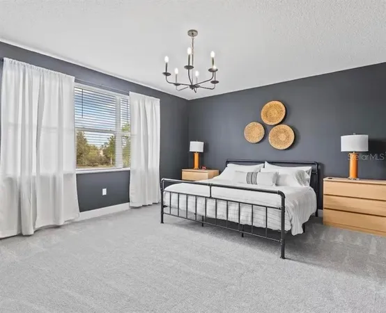 a bedroom with a bed and chandelier