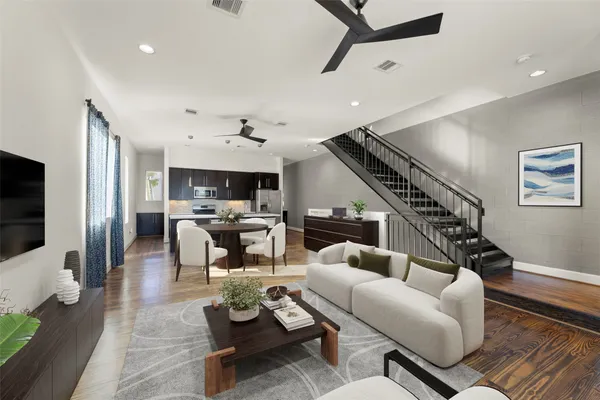 a living room with furniture kitchen view and a flat screen tv