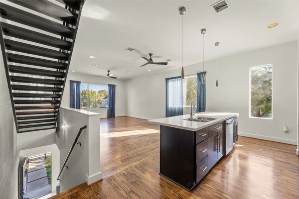 a kitchen with stainless steel appliances granite countertop a stove and a wooden floors