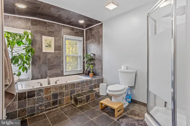 a bathroom with a tub sink and mirror