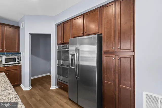 a metallic refrigerator freezer sitting inside of a kitchen