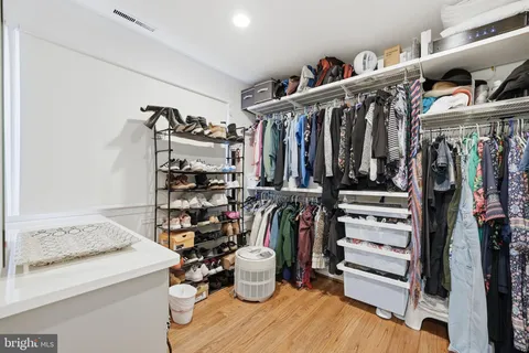 a view of walk in closet with clothes and shoes