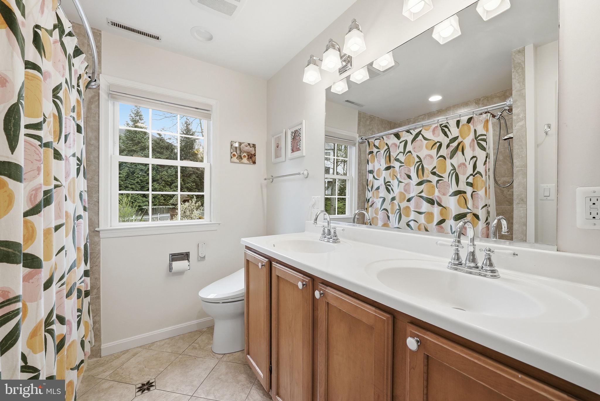 9503 Rockport Road Vienna, VA 22180 - Photo 30 of 48 a bathroom with a sink a toilet a mirror and a window