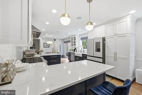 a kitchen with stainless steel appliances a dining table chairs and stove top oven
