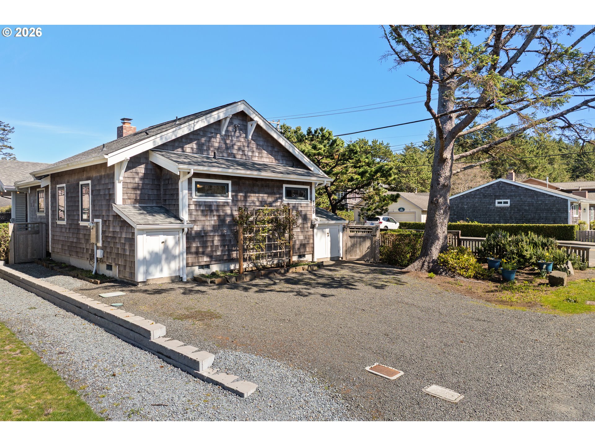 108 West Madison Street Cannon Beach, OR 97110 - Photo 40 of 45 a view of a house next to a yard with big trees