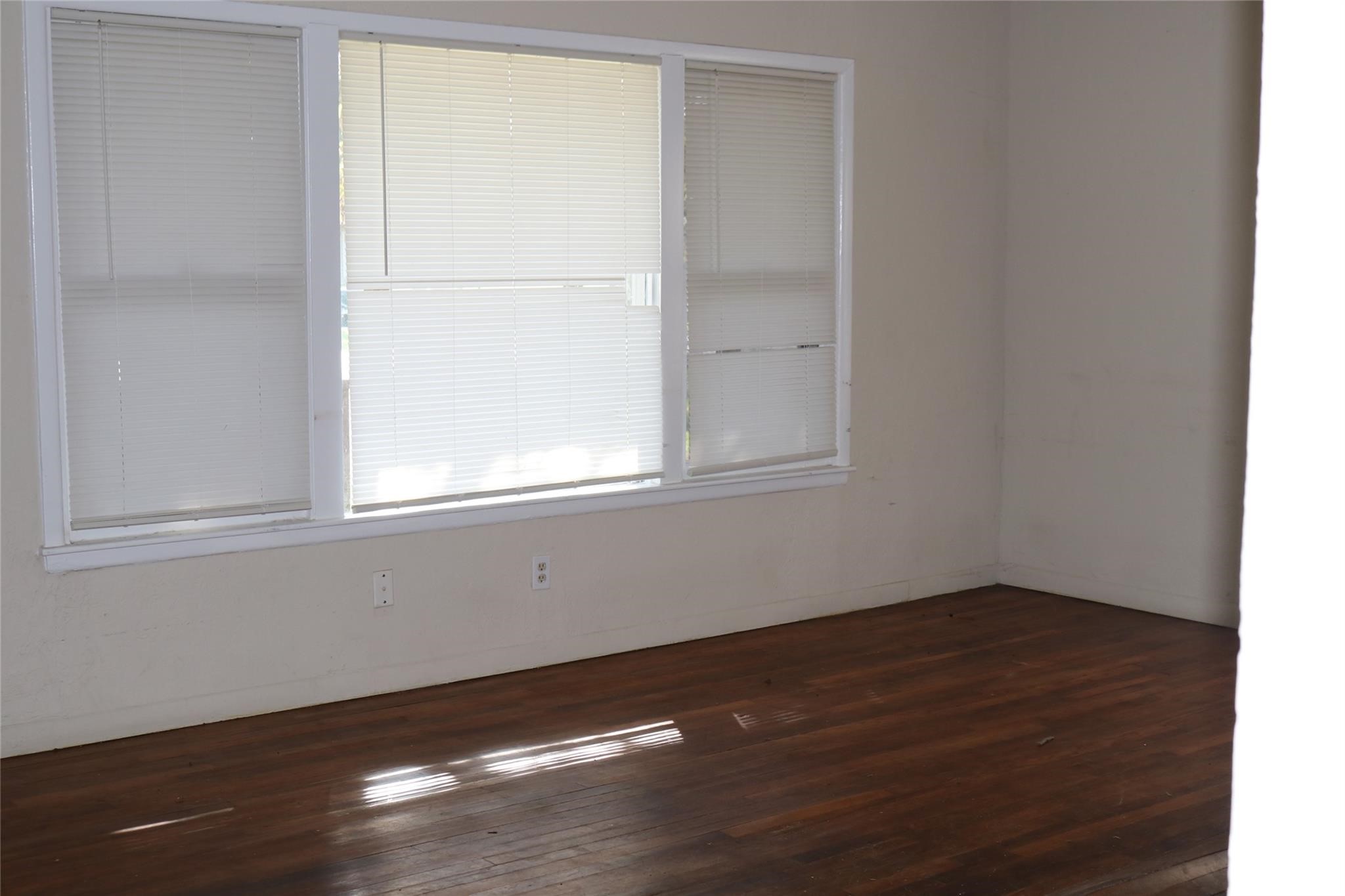 611 Nelson Street Crosby, TX 77532 - Photo 4 of 6 an empty room with wooden floor and windows