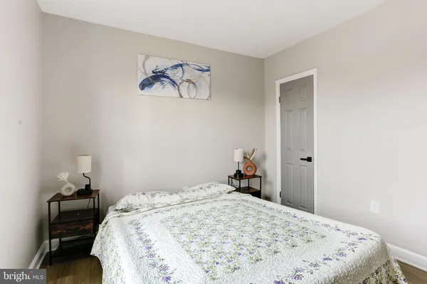 a bedroom with a bed and a painting on the wall
