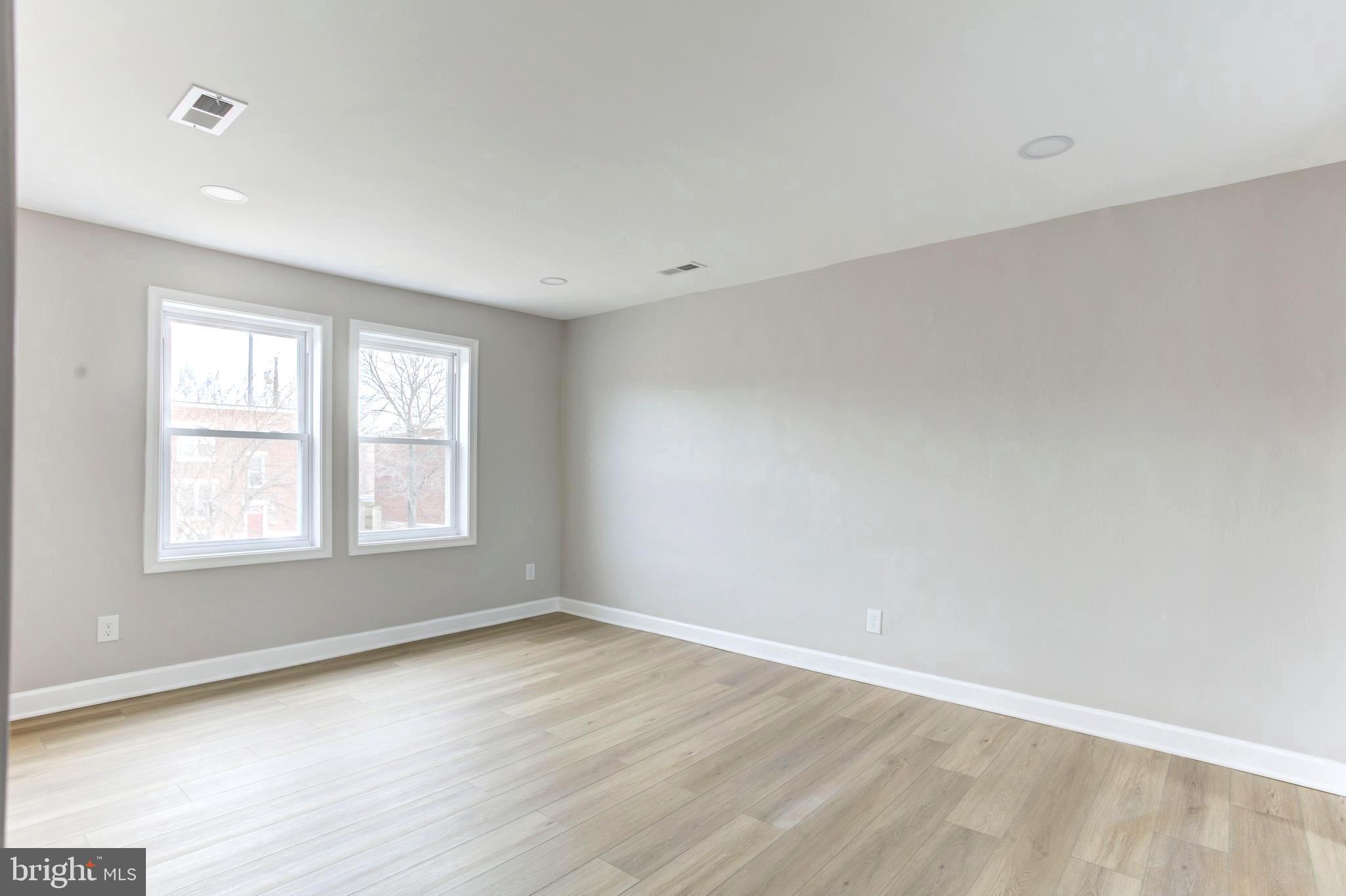 1012 Elton Avenue Baltimore, MD 21224 - Photo 18 of 30 an empty room with wooden floor and windows