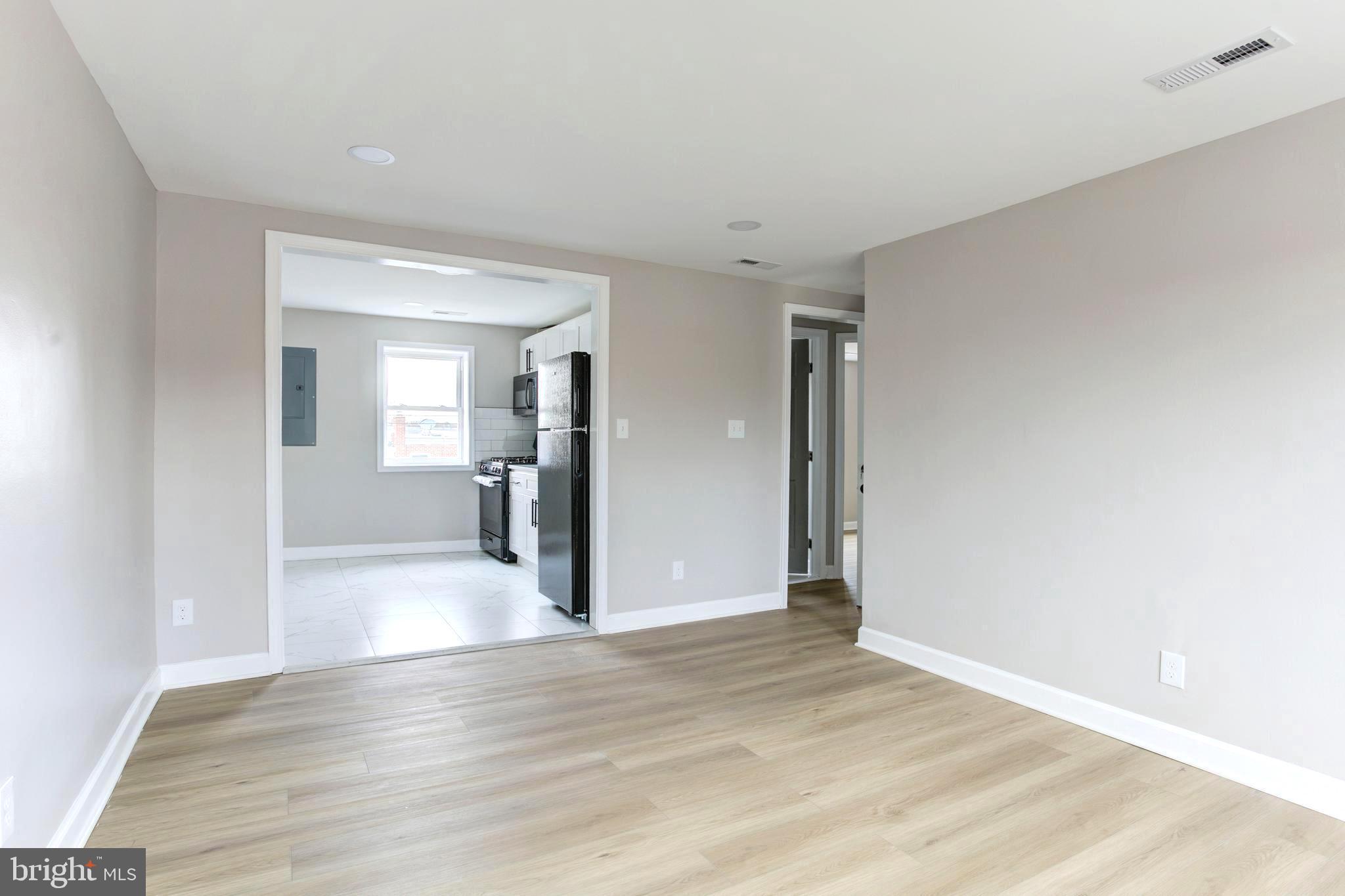1012 Elton Avenue Baltimore, MD 21224 - Photo 21 of 30 a view of a big room with wooden floor and a kitchen
