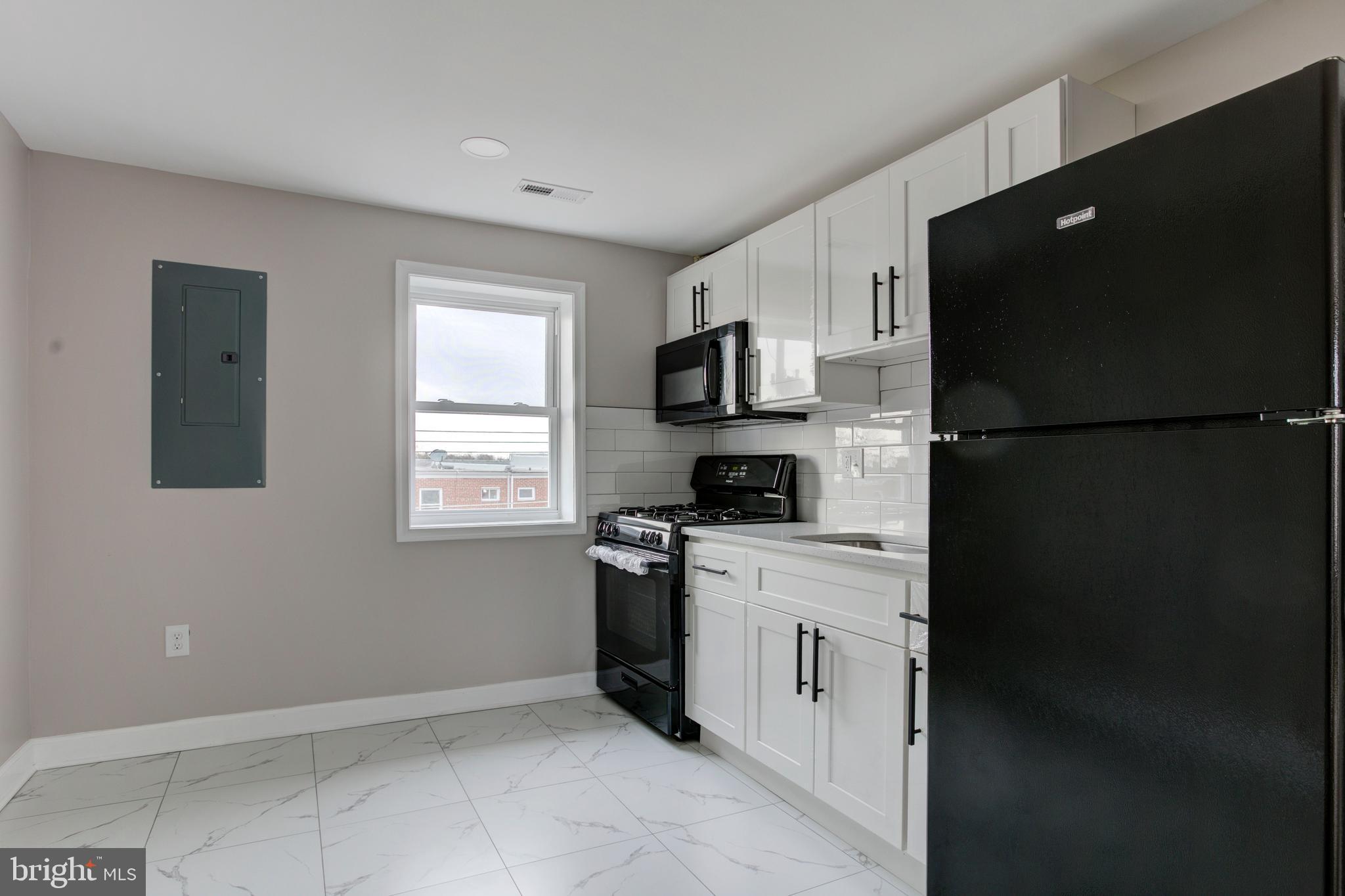 1012 Elton Avenue Baltimore, MD 21224 - Photo 23 of 30 a kitchen with a refrigerator stove and microwave