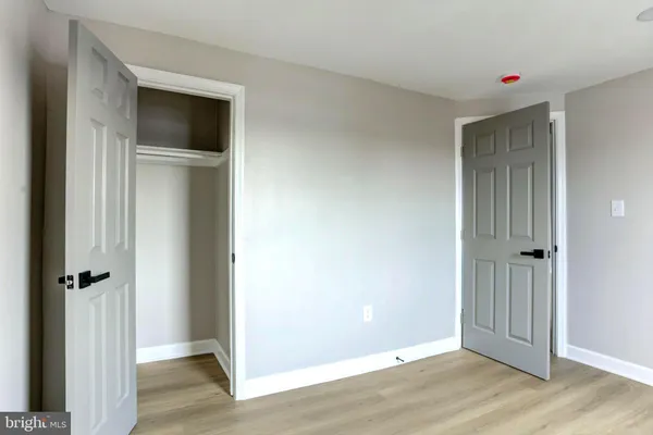 an empty room with wooden floor and closet