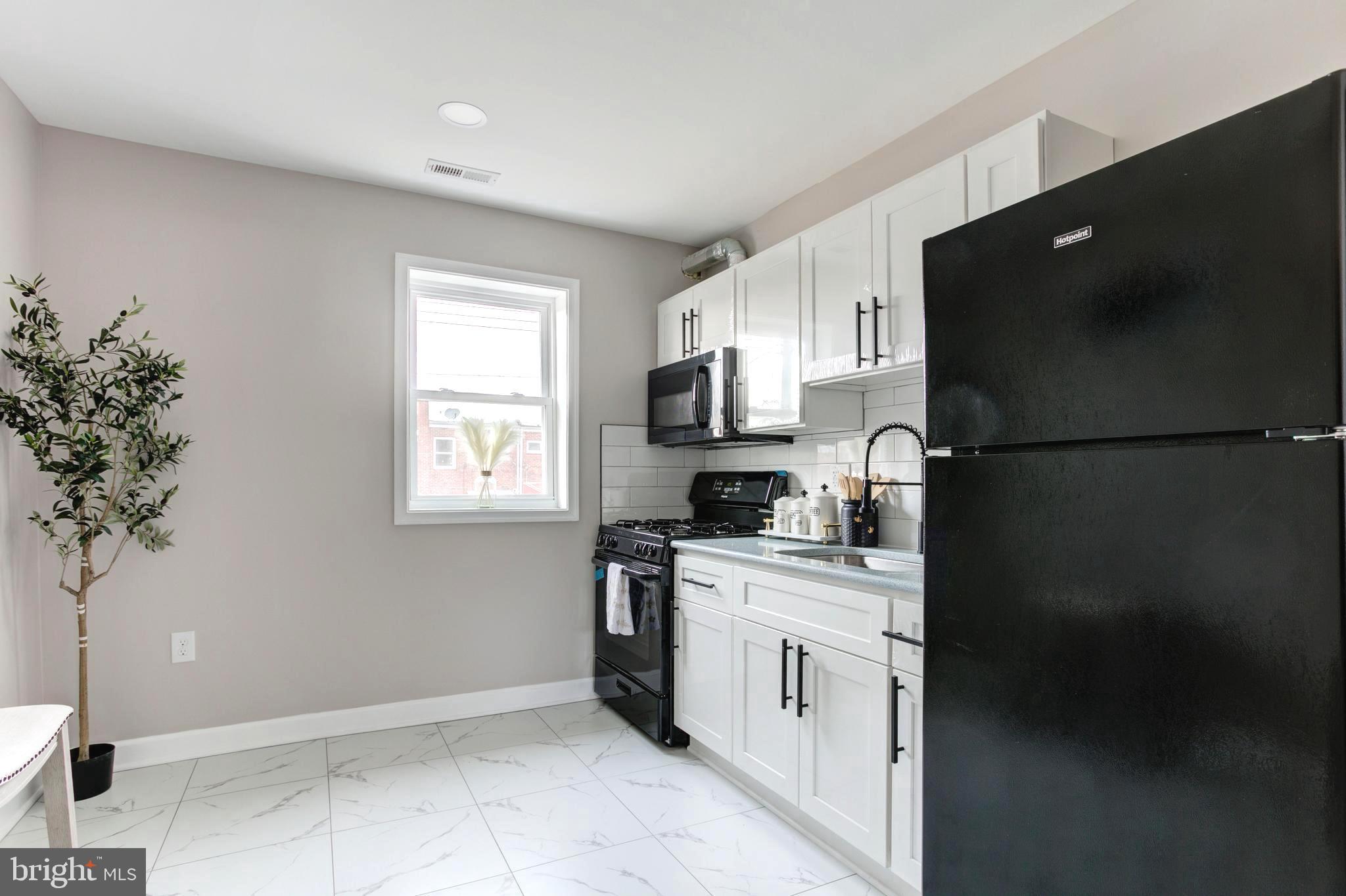 1012 Elton Avenue Baltimore, MD 21224 - Photo 8 of 30 a kitchen with a refrigerator and a stove top oven