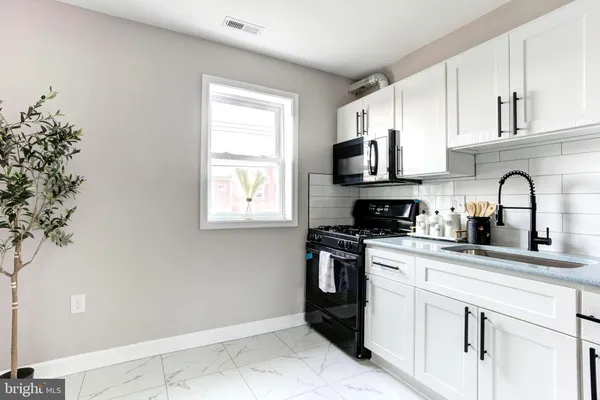 a kitchen with granite countertop a sink stainless steel appliances and cabinets