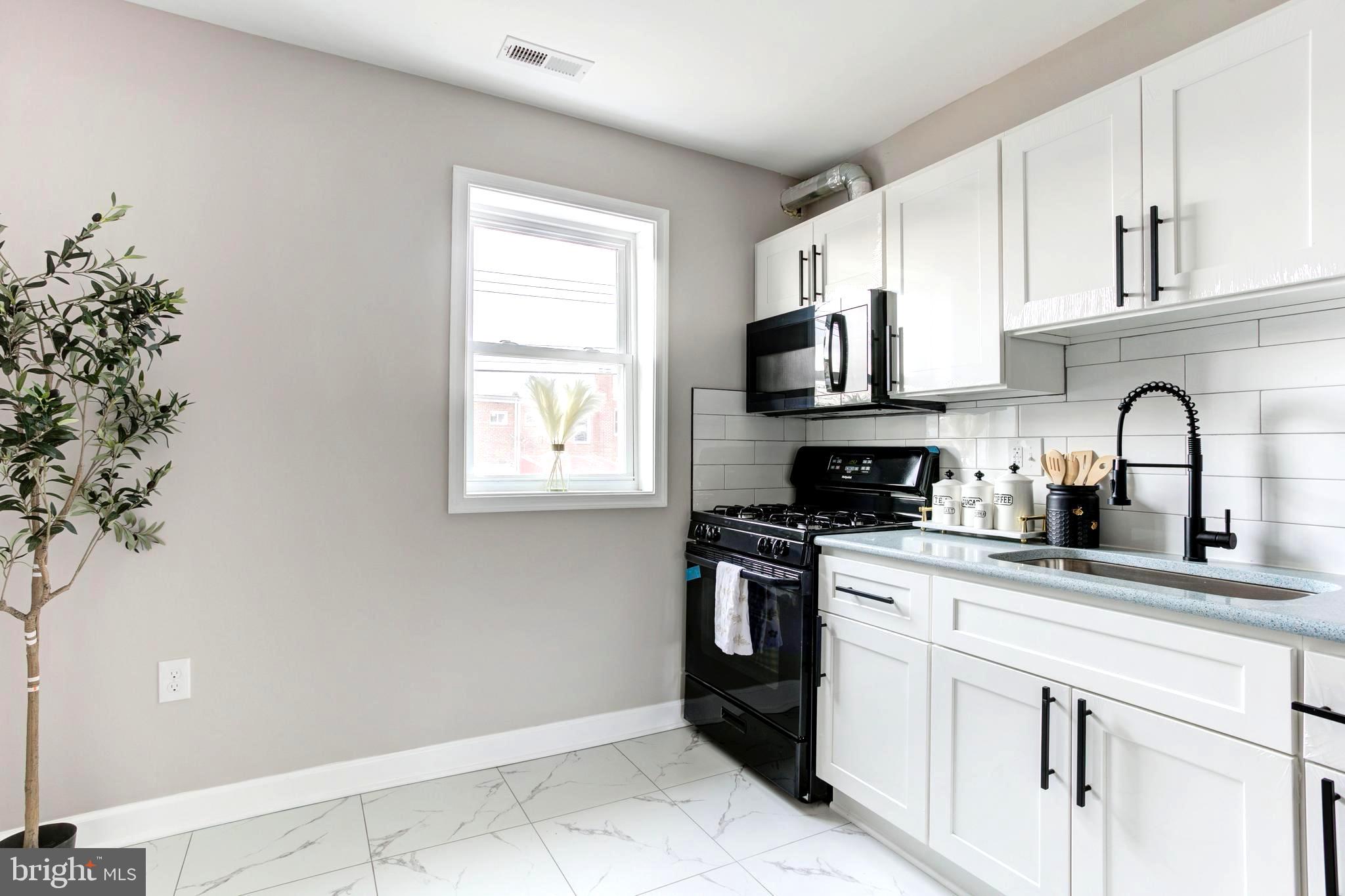 1012 Elton Avenue Baltimore, MD 21224 - Photo 9 of 30 a kitchen with granite countertop a sink stainless steel appliances and cabinets