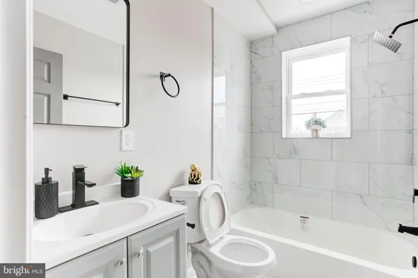 a bathroom with a tub sink and mirror