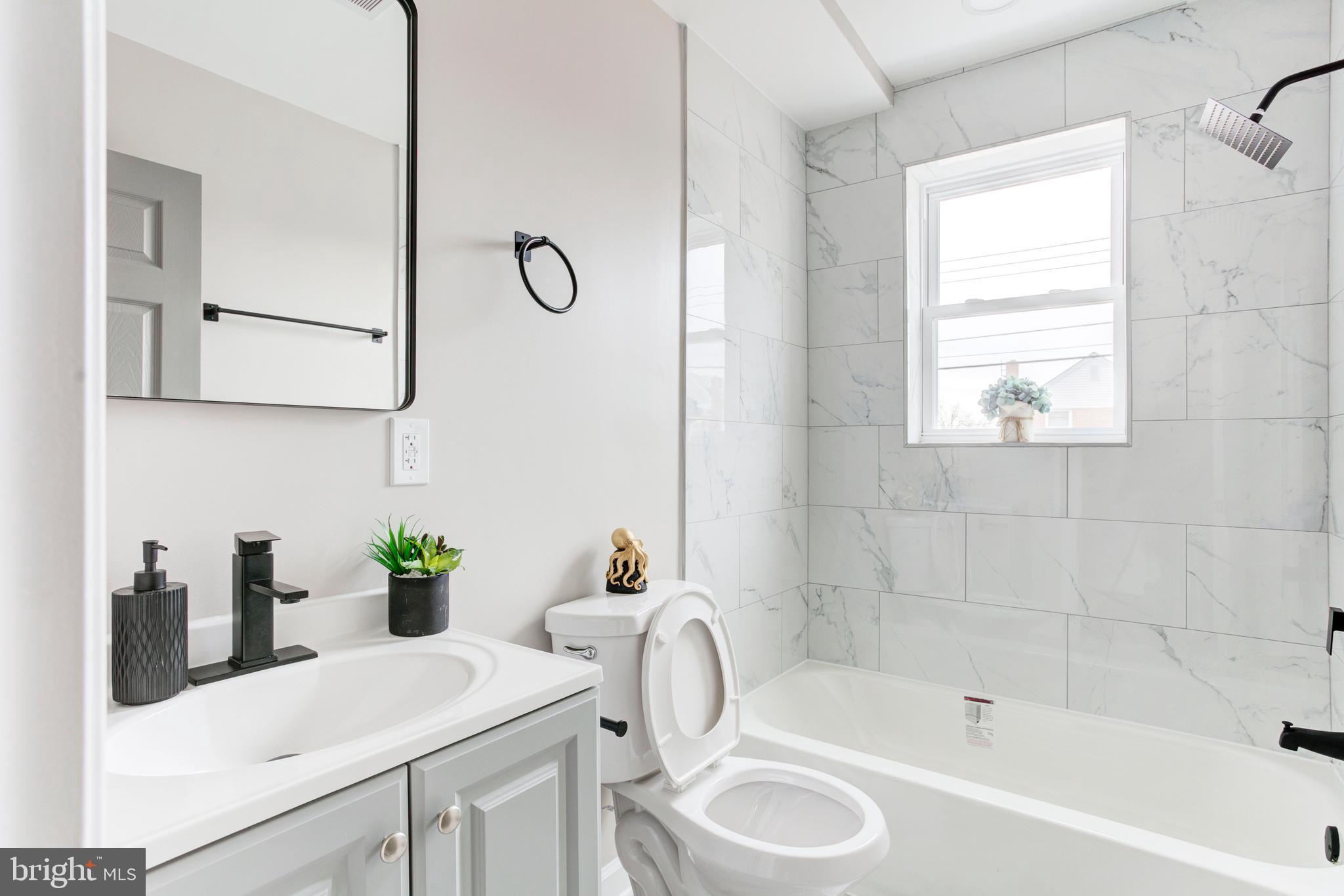 1012 Elton Avenue Baltimore, MD 21224 - Photo 10 of 30 a bathroom with a tub sink and mirror