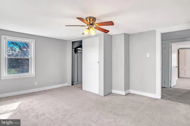 a view of a livingroom with a ceiling fan and window