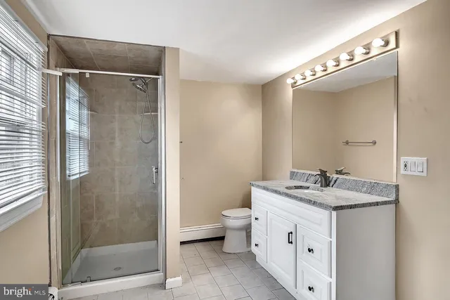 a bathroom with a double vanity sink mirror and toilet