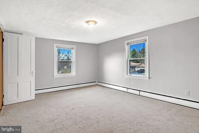 an empty room with windows and closet