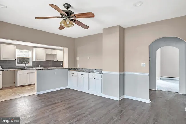 a view of a kitchen with sink hardwood floor and a ceiling fan