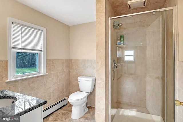 a bathroom with a toilet a shower and a window