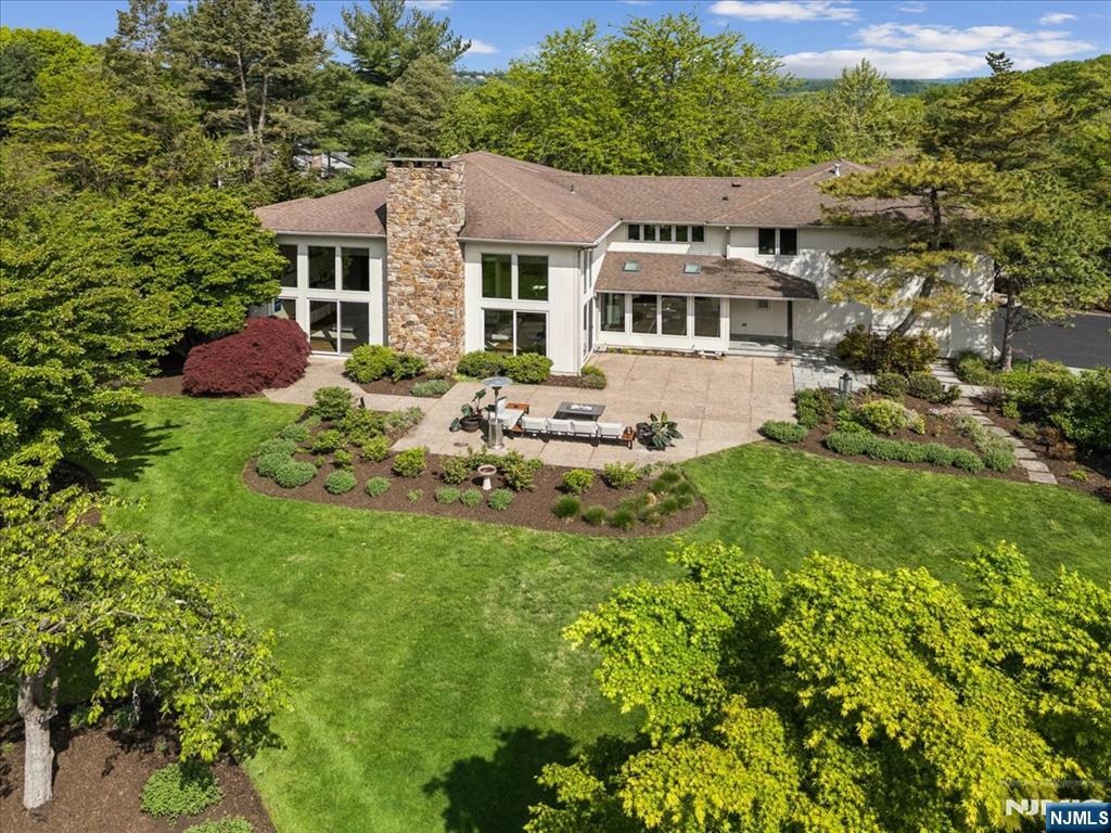 a front view of a house with a garden and trees