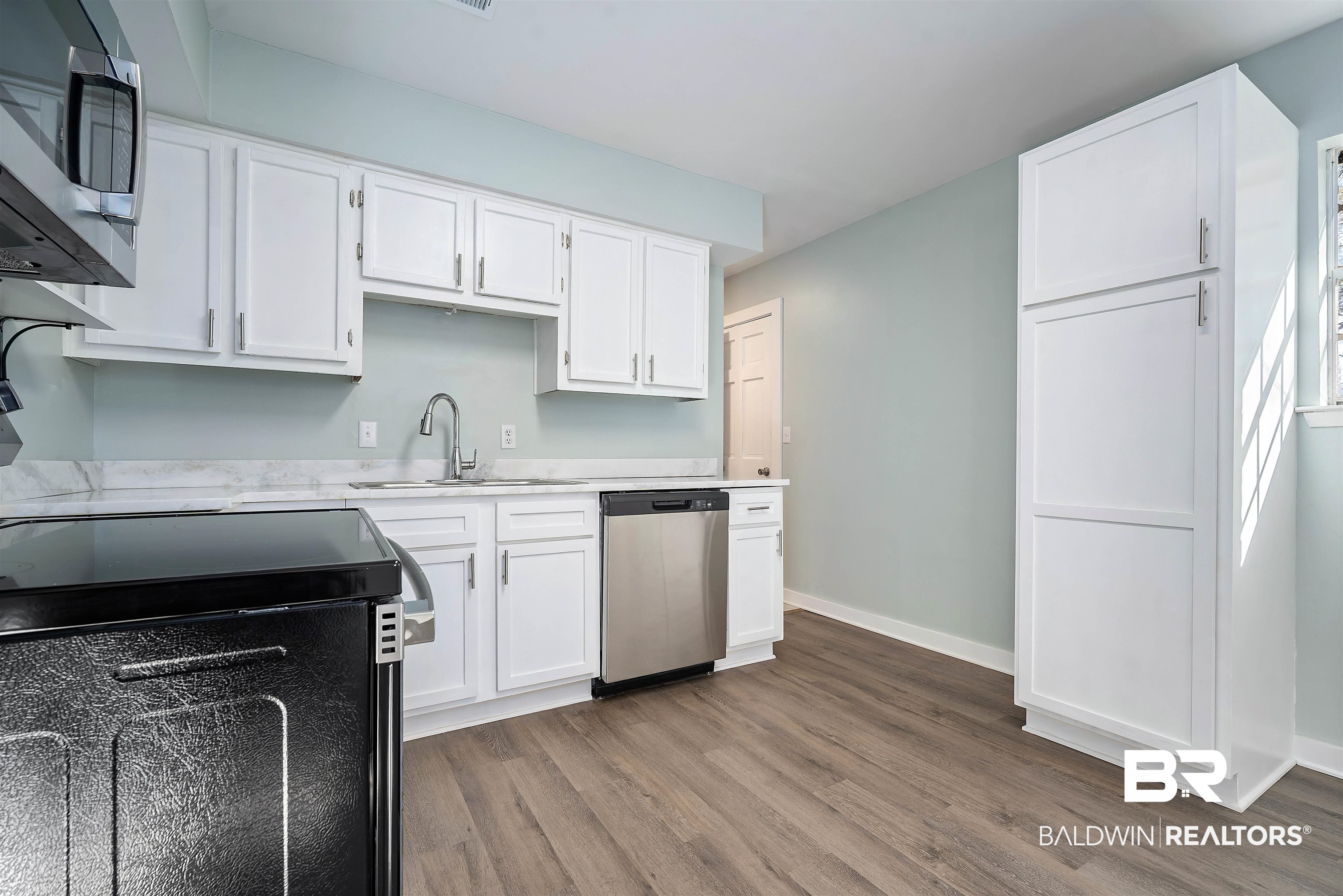 1368 Hubert Pierce Road Mobile, AL 36608 - Photo 10 of 25 Kitchen with appliances with stainless steel finishes, white cabinets, light countertops, and light wood-style floors
