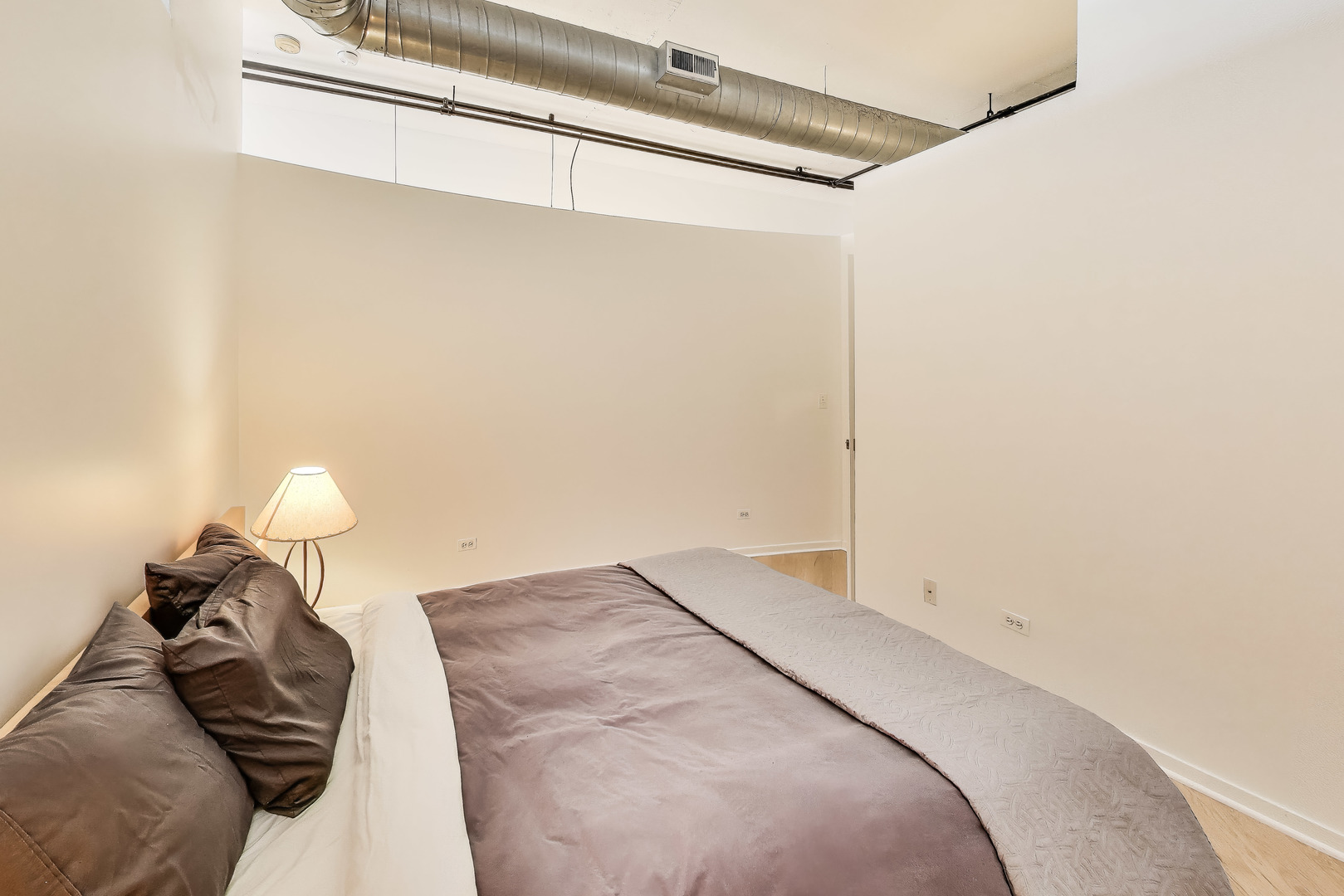 1000 West Adams Street, Unit 815 Chicago, IL 60607 - Photo 16 of 40 a bedroom with a bed and a chandelier