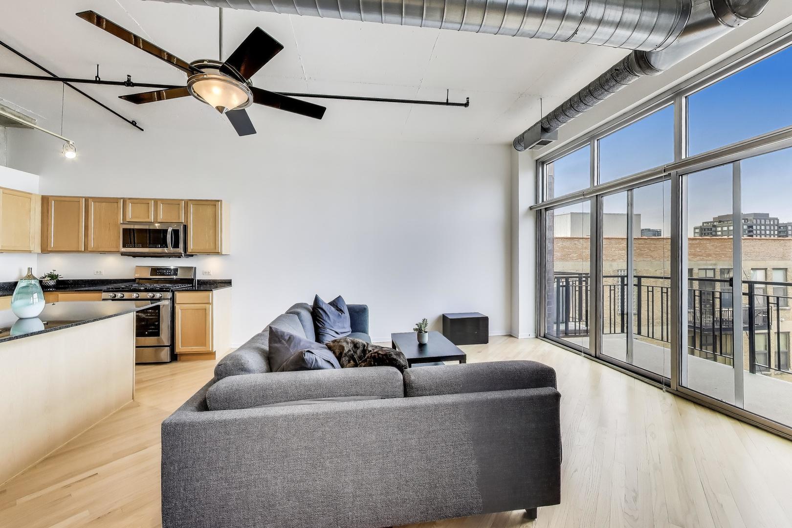 1000 West Adams Street, Unit 815 Chicago, IL 60607 - Photo 8 of 40 a living room with couches a flat screen tv and kitchen view