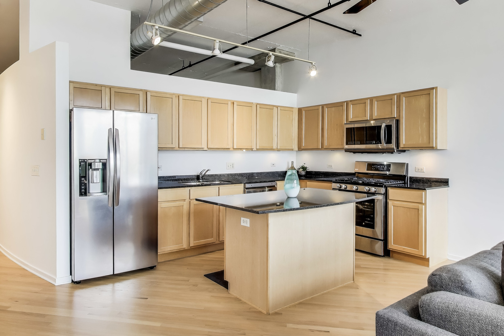1000 West Adams Street, Unit 815 Chicago, IL 60607 - Photo 10 of 40 a kitchen with stainless steel appliances granite countertop a refrigerator a stove a sink and a microwave