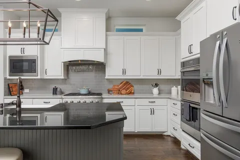 a kitchen with stainless steel appliances granite countertop a sink stove and refrigerator