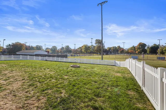 a view of a yard with wooden fence