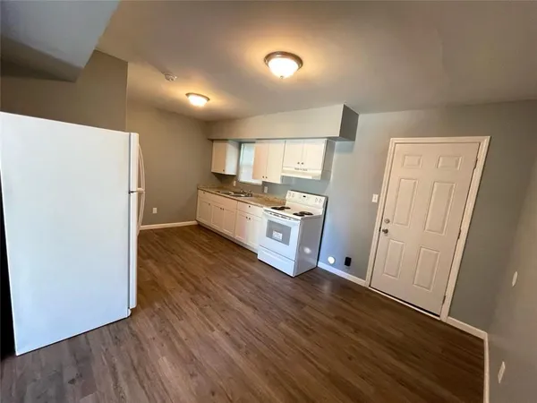 a kitchen with stainless steel appliances a refrigerator and wooden floor