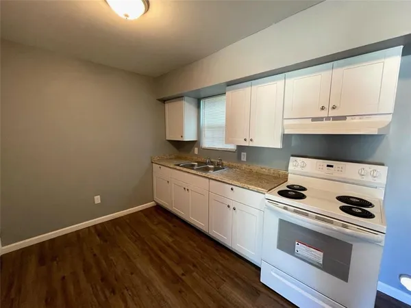 a kitchen with granite countertop white cabinets and white appliances