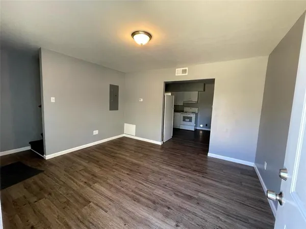 a view of empty room with wooden floor