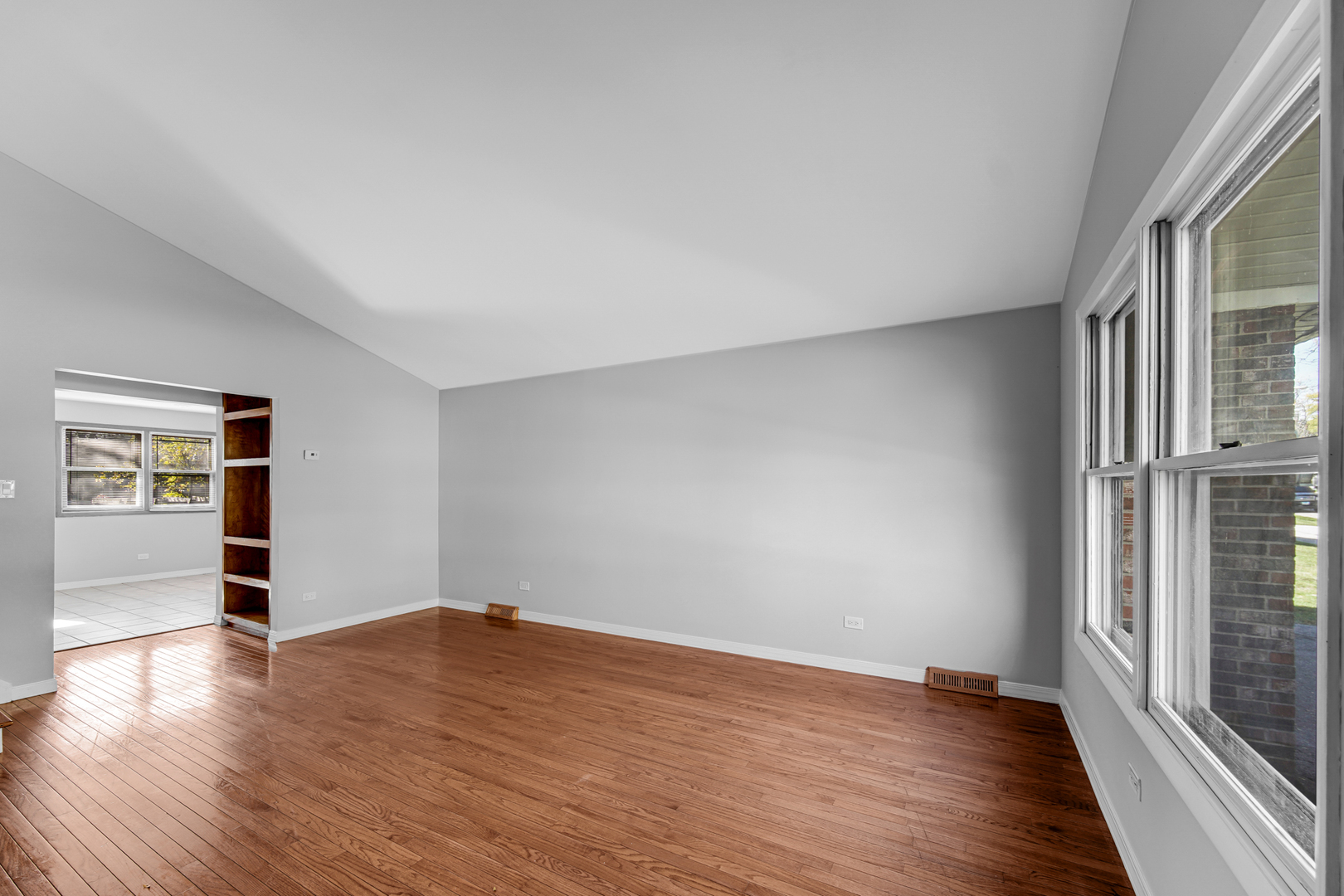 6159 Beechwood Road Matteson, IL 60443 - Photo 3 of 21 an empty room with wooden floor and windows