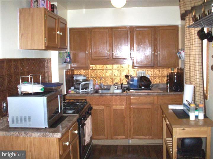 7119 Dungan Road Philadelphia, PA 19111 - Photo 6 of 15 a kitchen with granite countertop a stove a sink and a microwave