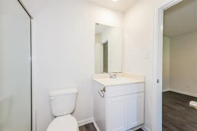 a bathroom with a toilet a sink and mirror