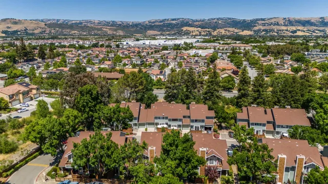 an aerial view of residential houses with outdoor space and trees