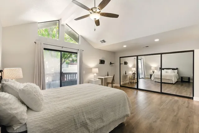 a spacious bedroom with a large bed and a chandelier