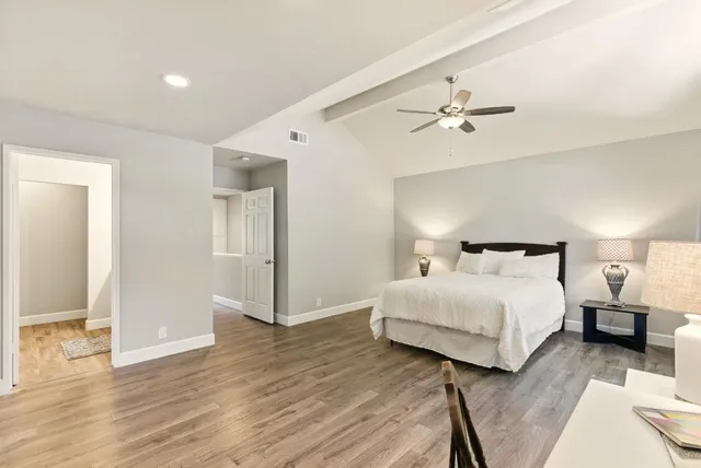 a bedroom with a bed and wooden floor