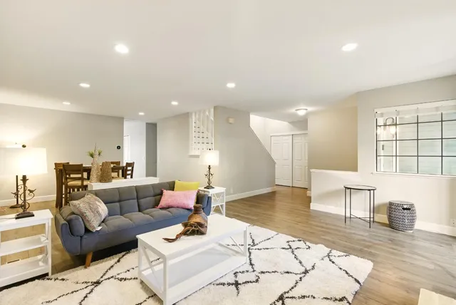 a living room with furniture and a wooden floor