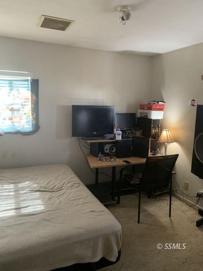425 North Fairview Street Ridgecrest, CA 93555 - Photo 3 of 9 a bedroom with a bed and a desk