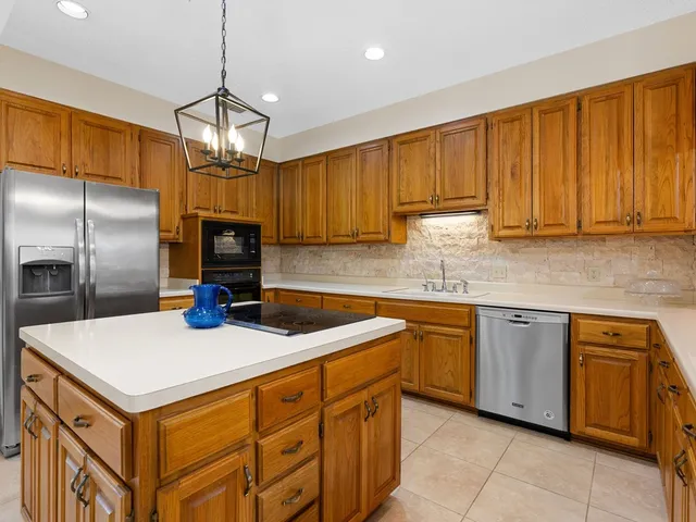 a kitchen with stainless steel appliances granite countertop a sink a stove and a refrigerator