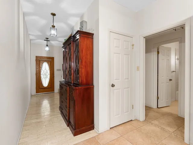 a view of a hallway with a cabinet and mirror