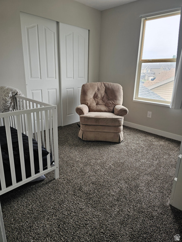 7481 Red Pine Road Eagle Mountain, UT 84005 - Photo 13 of 38 Second Bedroom with plush gray carpeted room featuring a double-pane window with white trim, light gray painted walls, andlarge closet doors