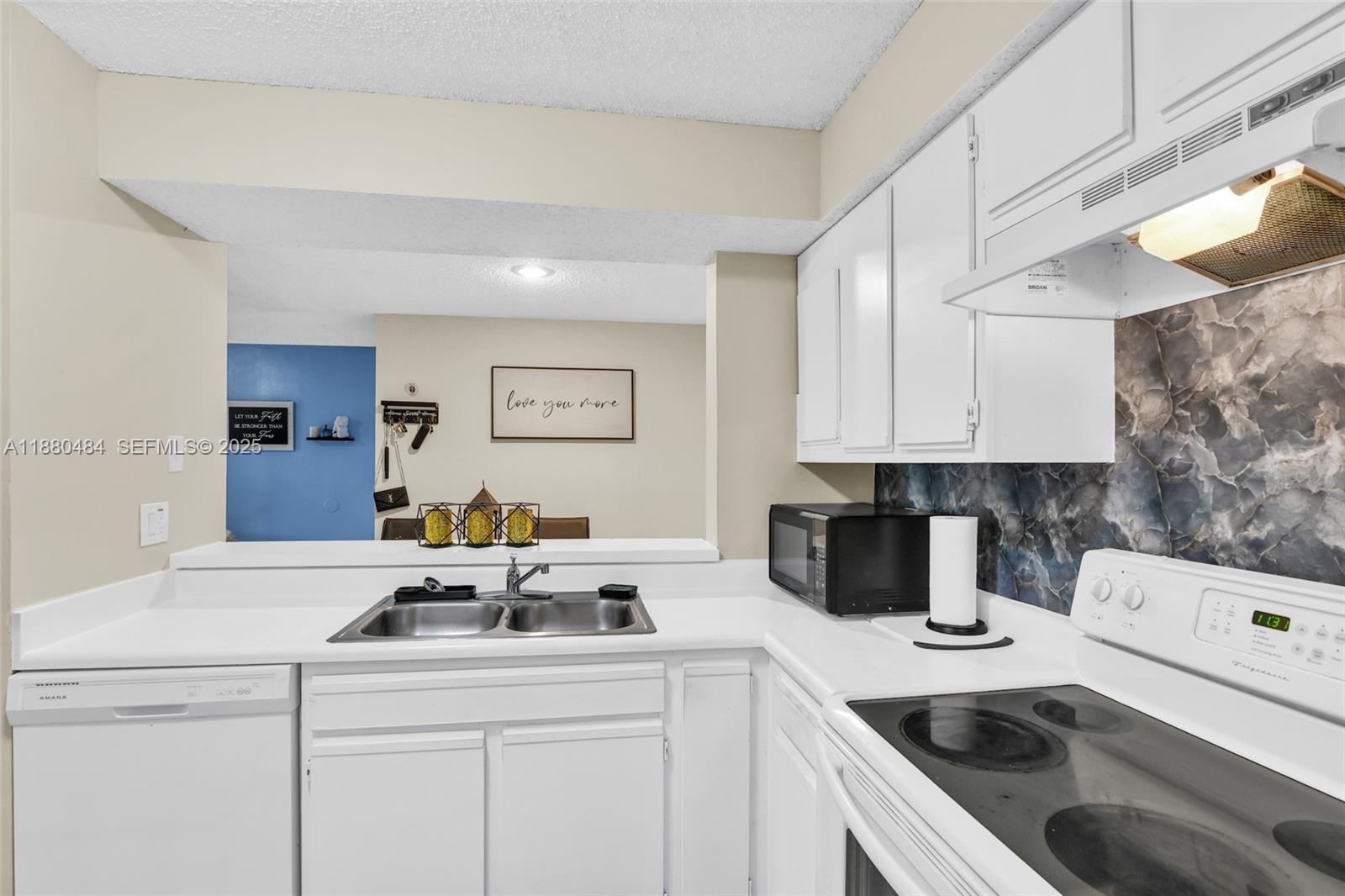 1255 Southwest 46th Avenue, Unit 1713 Pompano Beach, FL 33069 - Photo 12 of 37 a kitchen with a sink a stove and cabinets