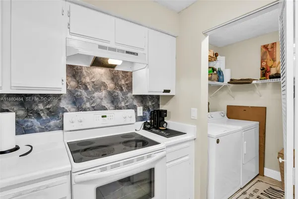 a kitchen with a stove and white cabinets